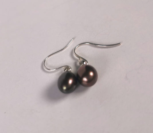 Boucles d'oreilles perles noires  bronze, ovales 6-8mm, montées sur pendants argent, posées sur un fond blanc pendants vers le haut, vue de dessus d'en bas.