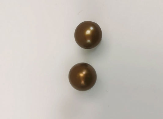 Boucles d'oreilles perles bronze 7.5mm montées sur clous. Présentées l'une au dessus de l'autre plantées sur un support blanc. Vue de dessus, clous non visibles , sous les perles.