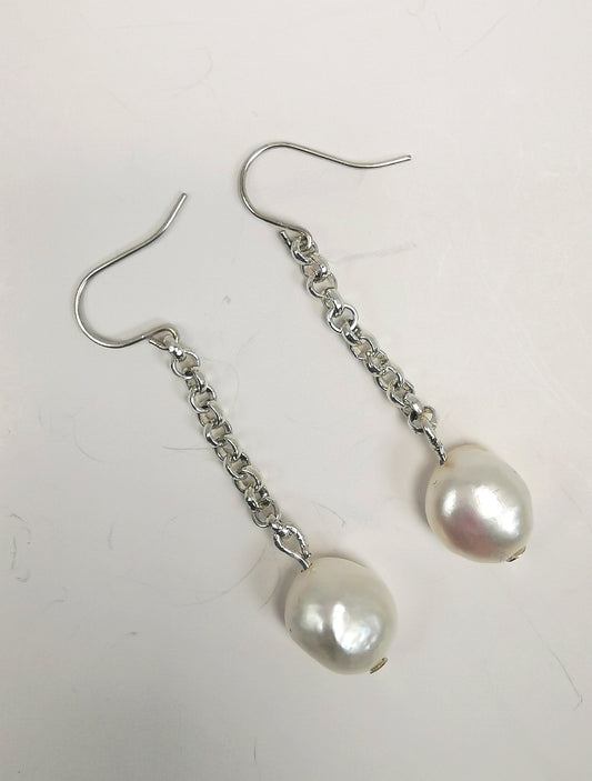 Boucles d'oreilles perles de culture blanche baroques, 12mm, sur pendants et chaine 40mm argent. Les deux sont présentées cote à cote, perles en bas, légèrement inclinées sur droite. Vue de dessus.