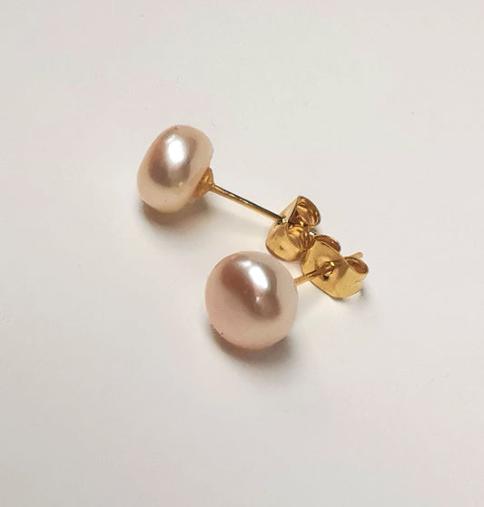 Boucles d'oreilles perles de culture roses 8.5mm sur clous plaqués or. Présentées cote à cote, horizontalement,  perles à gauche, sur fond blanc. Vue de coté en gros plan.