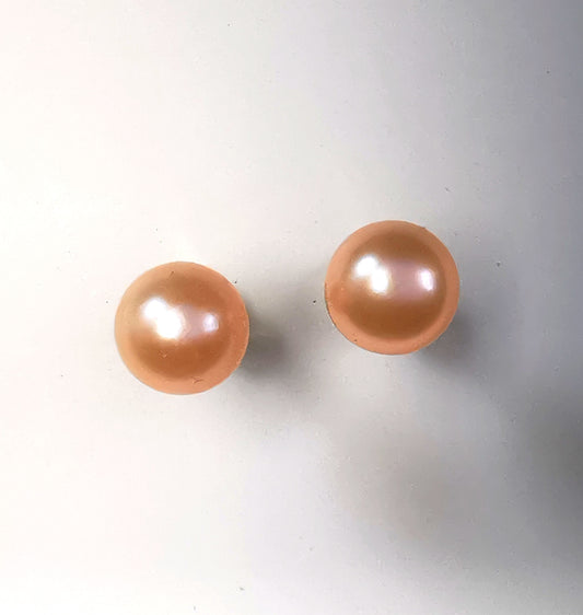 Boucles d'oreilles perles de culture roses 5mm sur clous plaqués or. Présentées plantées cote à cote sur un fond blanc. Vue de dessus.