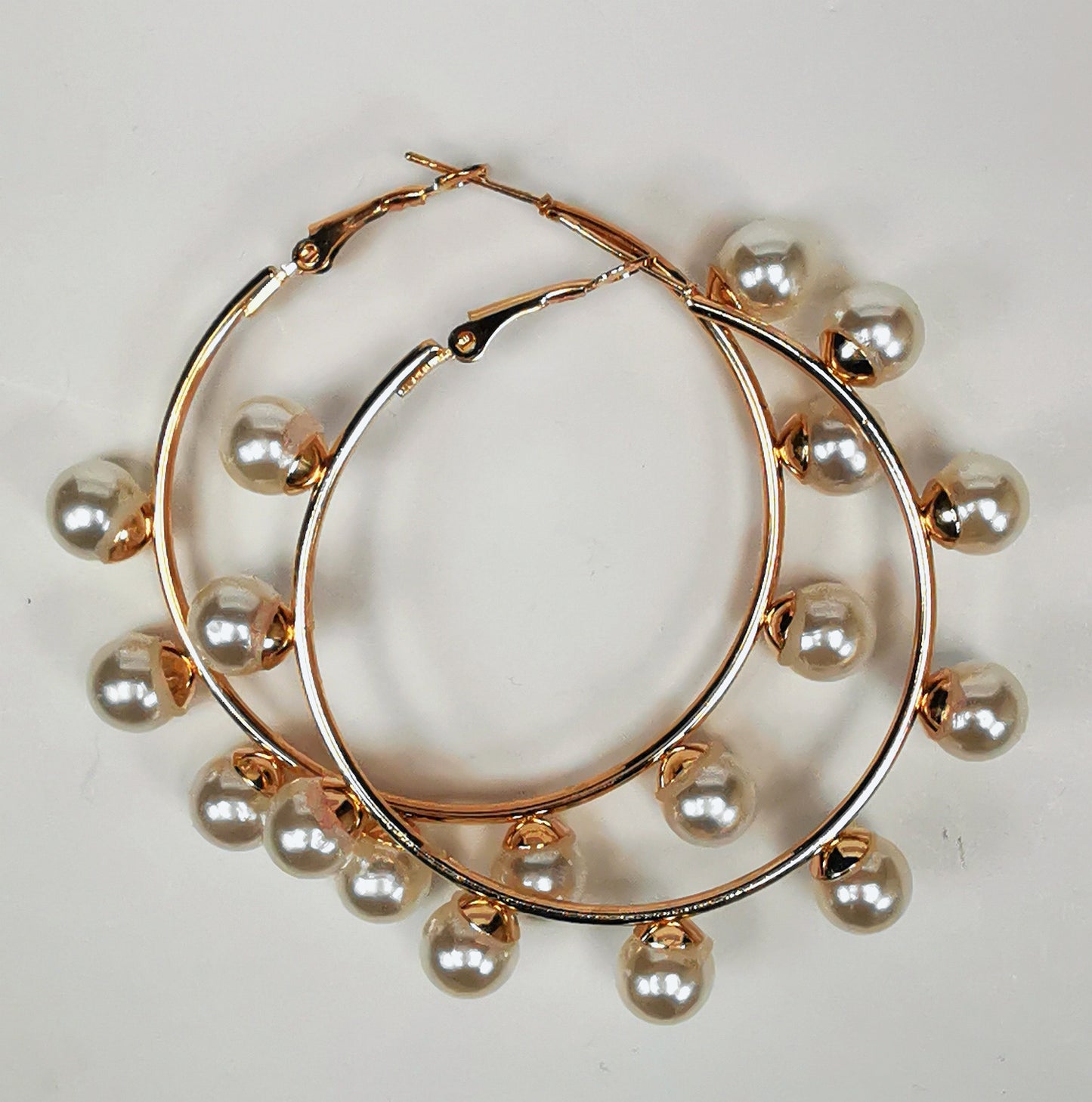 Boucles d'oreilles créoles et perles, diamètre 35mm, fil 1.5mm avec 9 perles de 8mm sur la périphérie. Présentées posées sur un fond blanc, l'une sur l'autre , vue de dessus.