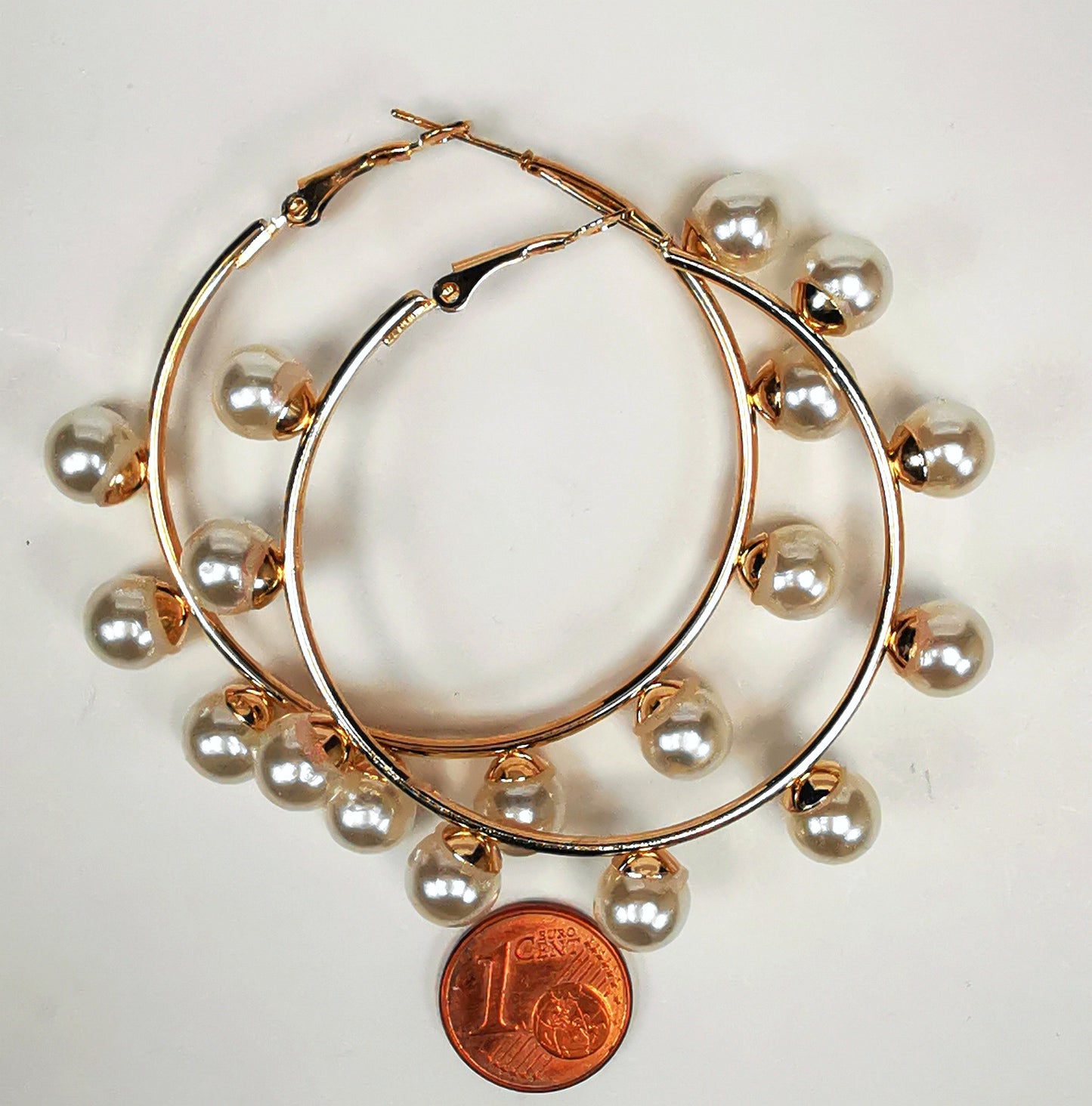 Boucles d'oreilles créoles et perles, diamètre 35mm, fil 1.5mm avec 9 perles de 8mm sur la périphérie. Présentées posées sur un fond blanc, l'une sur l'autre  au dessus d'une pièce de 1 centime, vue de dessus.