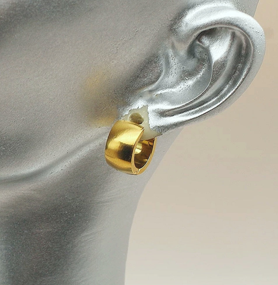 Boucle d'oreille en inox doré. Anneau épais de 12mm de diamètre et 8mm de large, articulé avec fermoir. Présentée  portée par un mannequin buste gris, vue de trois quarts face.